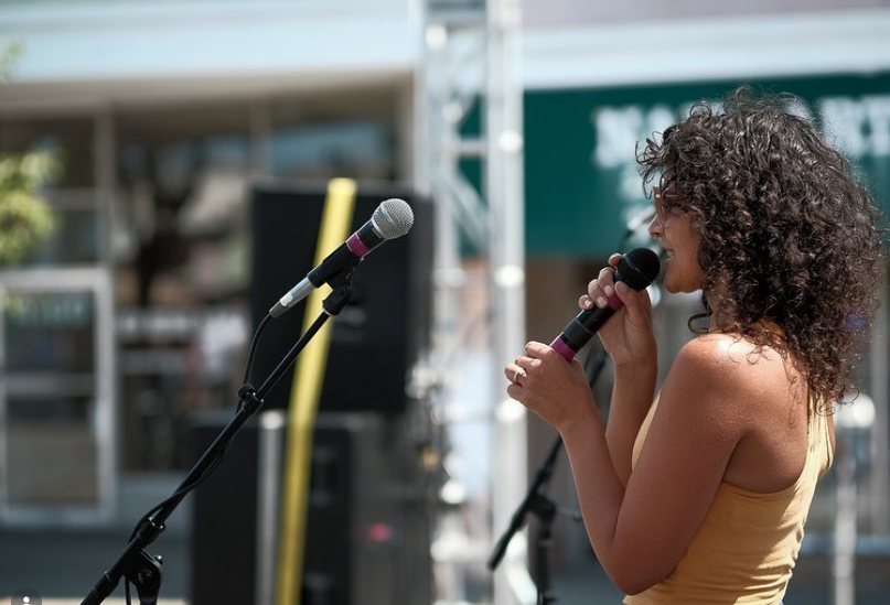Candi Martinez on the mic at an Oakland street fair